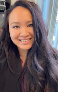 A woman with long hair smiles for the camera.