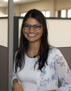 A woman with glasses smiling for the camera.