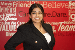 A woman standing in front of a red wall.